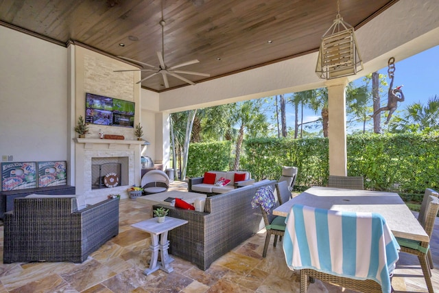 view of patio with an outdoor living space with a fireplace and ceiling fan