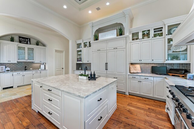 interior space with a high ceiling, light hardwood / wood-style flooring, a notable chandelier, crown molding, and a fireplace