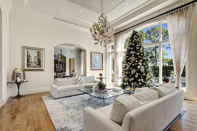 living room with crown molding, hardwood / wood-style floors, and a notable chandelier