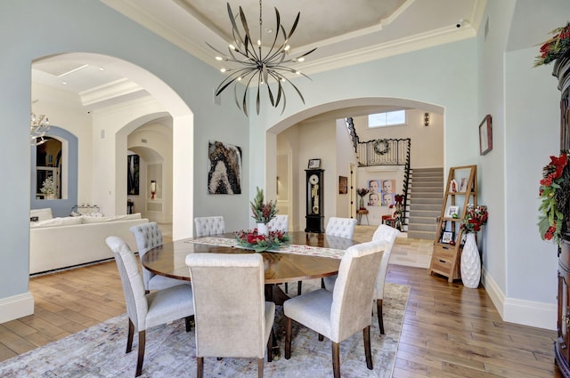 dining space featuring hardwood / wood-style floors, crown molding, and a notable chandelier