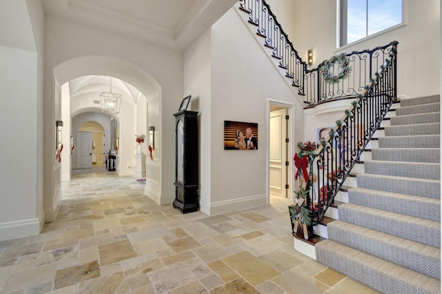 entryway with crown molding and a towering ceiling