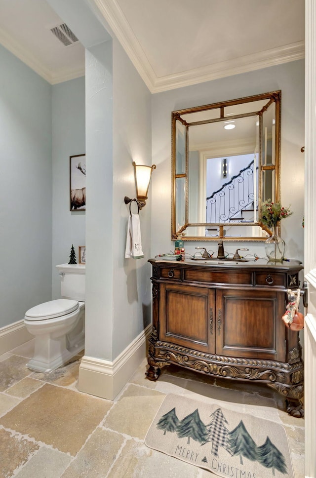 bathroom featuring vanity, toilet, and ornamental molding