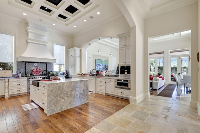 kitchen with crown molding, a wealth of natural light, and coffered ceiling