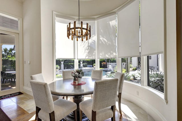 dining room with plenty of natural light, light hardwood / wood-style floors, and an inviting chandelier