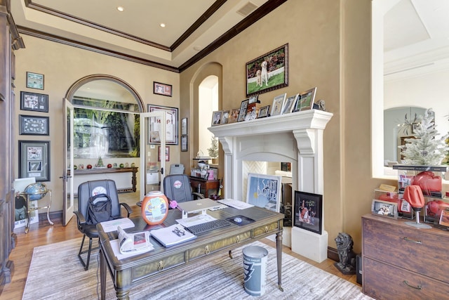 office space featuring a fireplace, light hardwood / wood-style floors, and ornamental molding