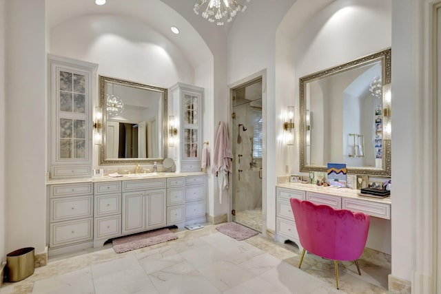 bathroom featuring vanity, an inviting chandelier, a shower with door, and lofted ceiling