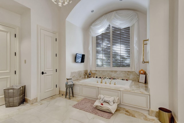 bathroom featuring a bathing tub and a notable chandelier