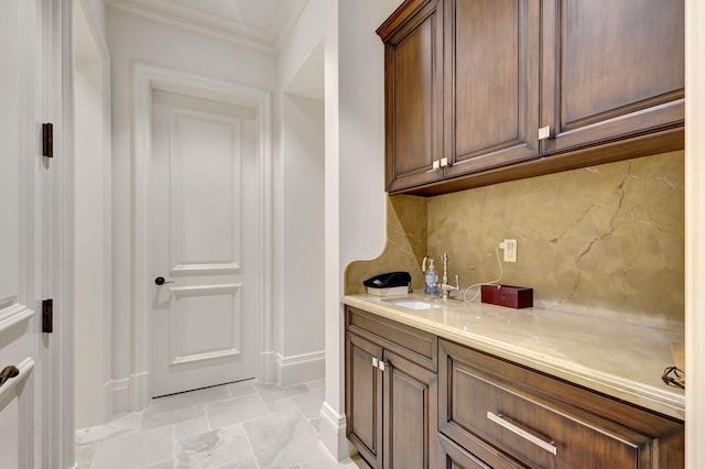 bathroom featuring decorative backsplash, vanity, and crown molding