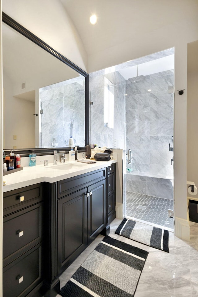 bathroom featuring vanity, vaulted ceiling, and a shower with door