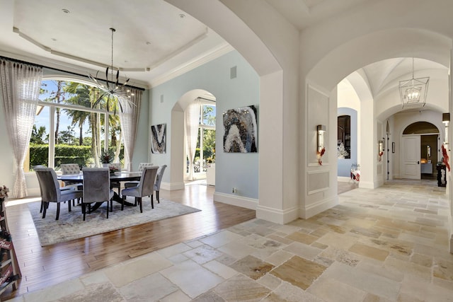 dining area with light wood-type flooring, ornamental molding, and an inviting chandelier