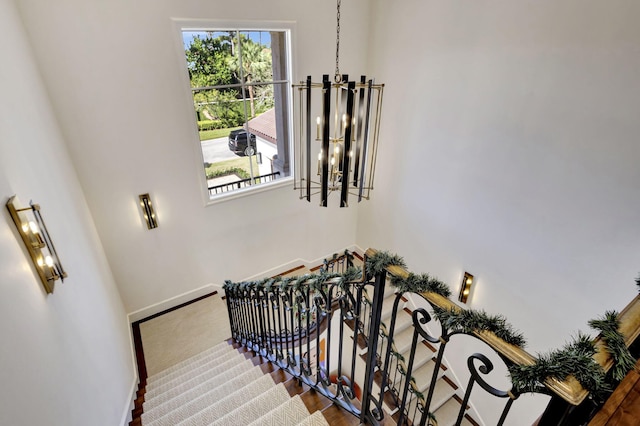 stairs featuring hardwood / wood-style flooring and a notable chandelier