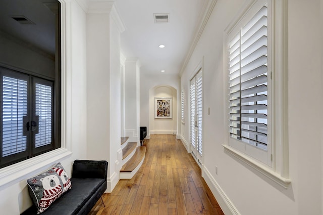 hallway with wood-type flooring and crown molding