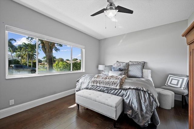 bedroom featuring dark wood-type flooring, ceiling fan, and a textured ceiling