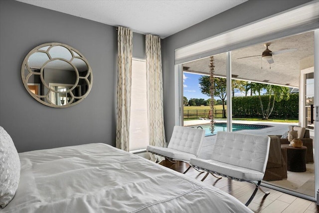 bedroom featuring a textured ceiling, light hardwood / wood-style floors, and access to outside