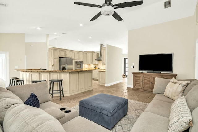 living room featuring ceiling fan, lofted ceiling, light tile patterned flooring, and sink