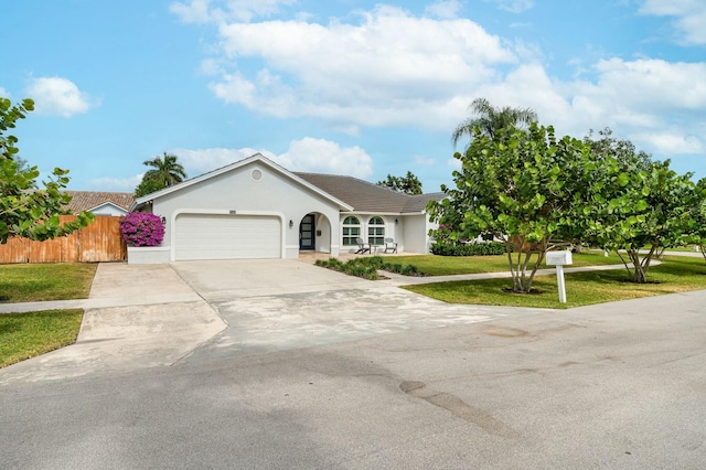 ranch-style home with a garage and a front lawn