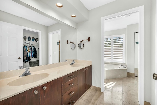 bathroom featuring tiled bath, tile patterned floors, and vanity