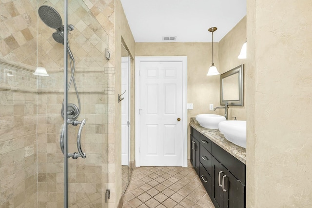 bathroom featuring a shower with shower door and vanity