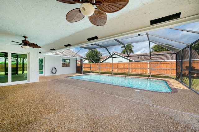 view of pool with a patio area, ceiling fan, and glass enclosure