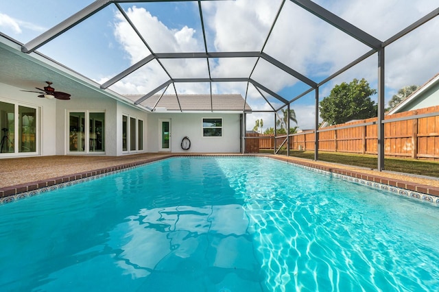 view of pool with ceiling fan and glass enclosure