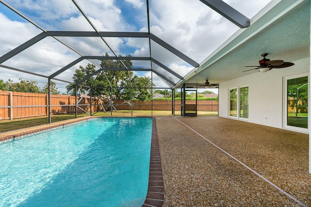 view of pool featuring ceiling fan, glass enclosure, and a patio area