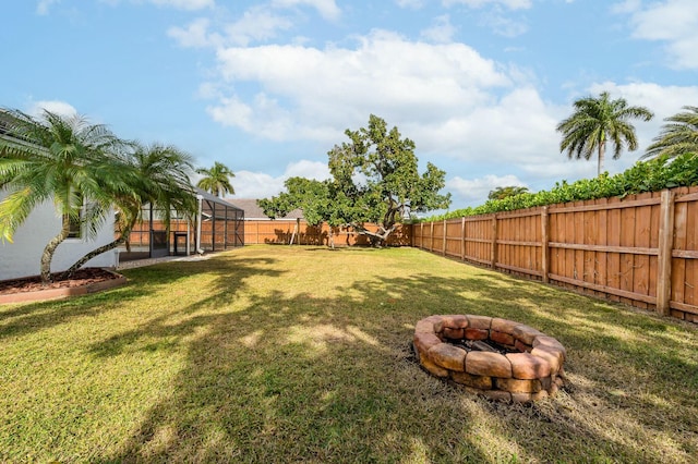 view of yard with an outdoor fire pit and a lanai