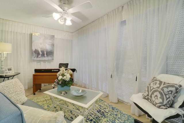 sitting room featuring ceiling fan and a textured ceiling