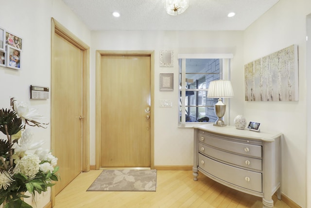 entrance foyer with a textured ceiling and light wood-type flooring