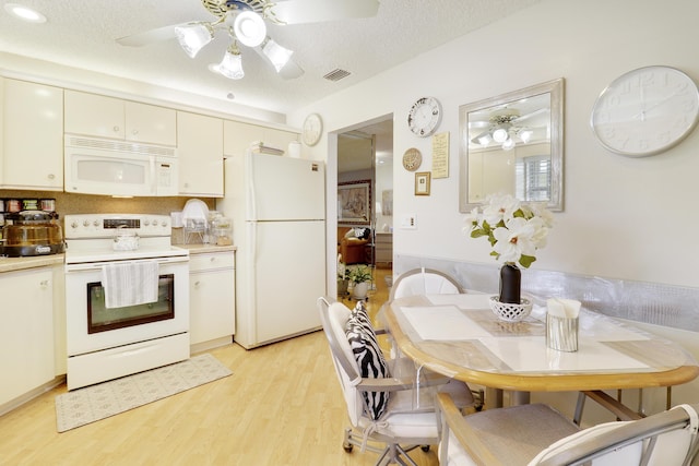 kitchen with white appliances, a textured ceiling, and light hardwood / wood-style flooring