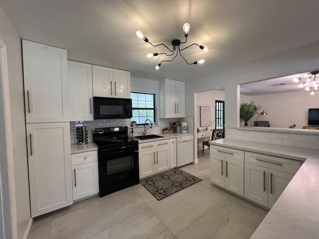 kitchen with backsplash, sink, white cabinets, and black appliances