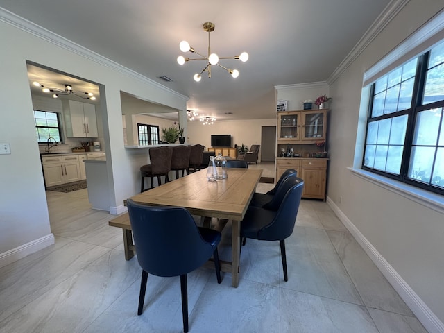 dining area with sink, ceiling fan with notable chandelier, and ornamental molding