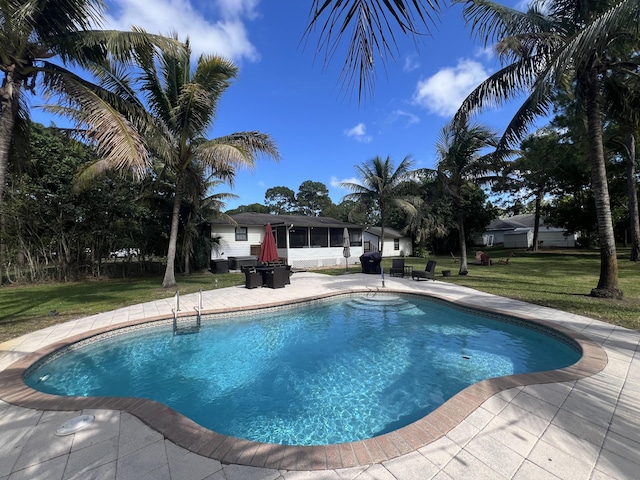 view of swimming pool featuring a lawn and a patio