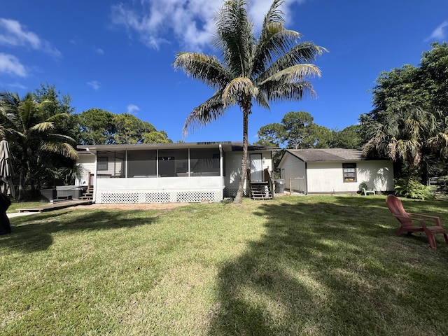 rear view of property with a sunroom and a yard