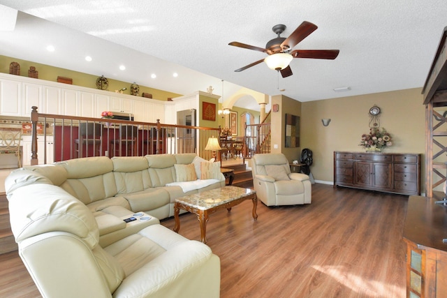 living room featuring ceiling fan, wood-type flooring, and a textured ceiling