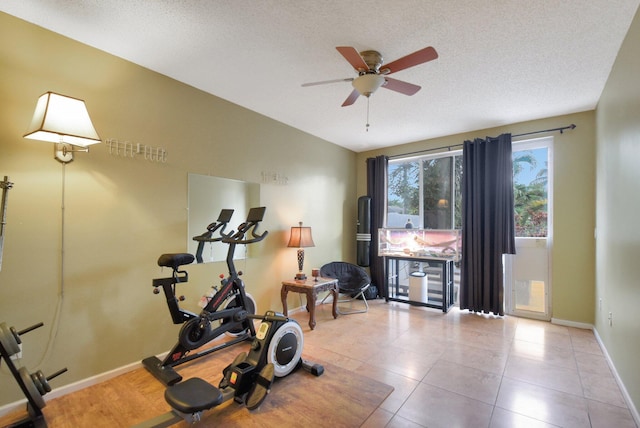 exercise area featuring ceiling fan and a textured ceiling