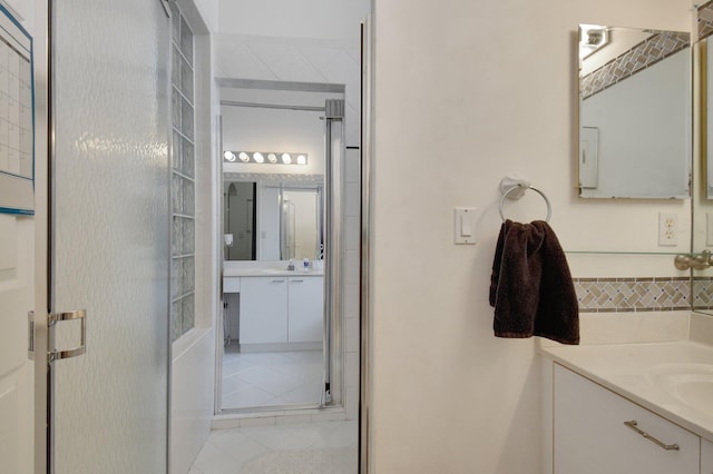 bathroom featuring tile patterned flooring, vanity, and a shower with door