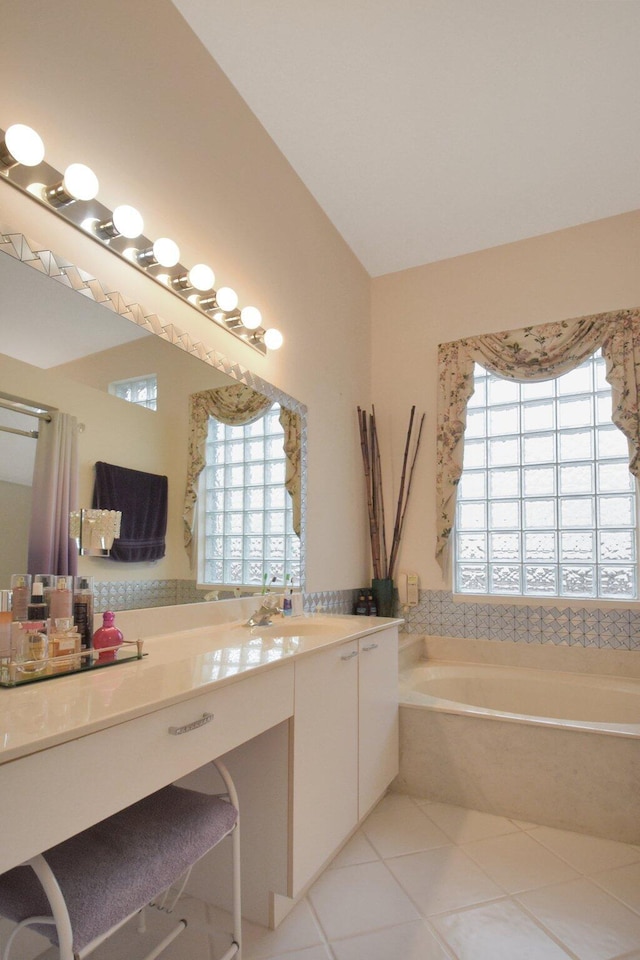 bathroom with vanity, tile patterned flooring, and a relaxing tiled tub