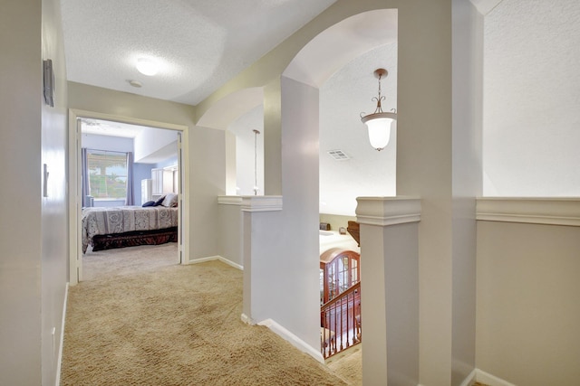 corridor featuring carpet flooring and a textured ceiling