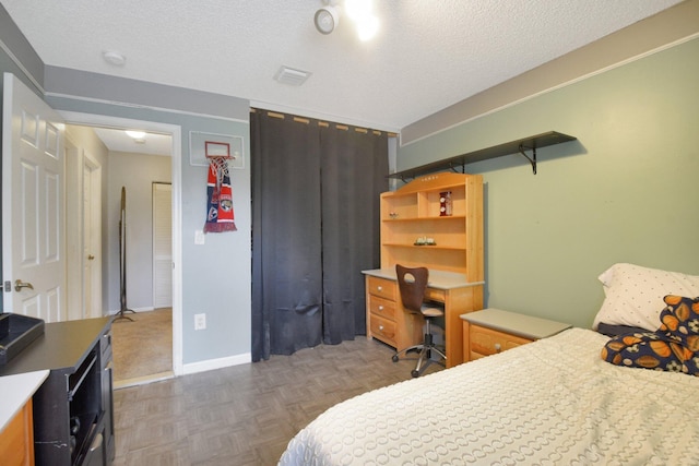 bedroom featuring dark parquet floors and a textured ceiling