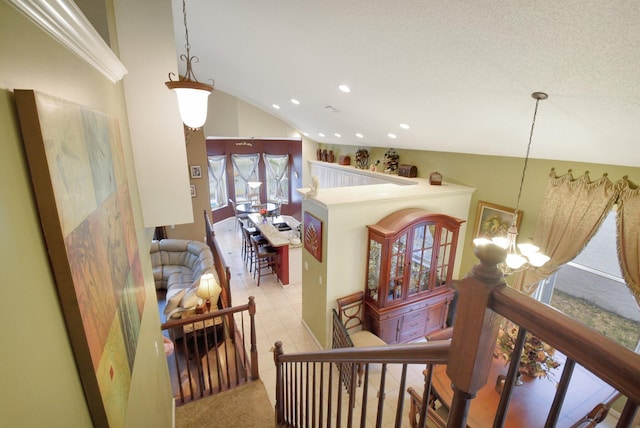 corridor featuring lofted ceiling and a notable chandelier