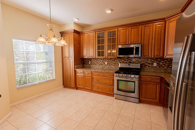 kitchen with decorative light fixtures, light tile patterned flooring, a chandelier, and appliances with stainless steel finishes