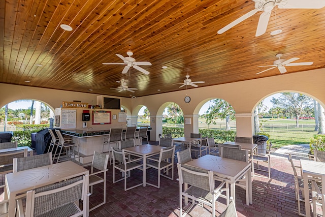 view of patio / terrace with ceiling fan and a bar