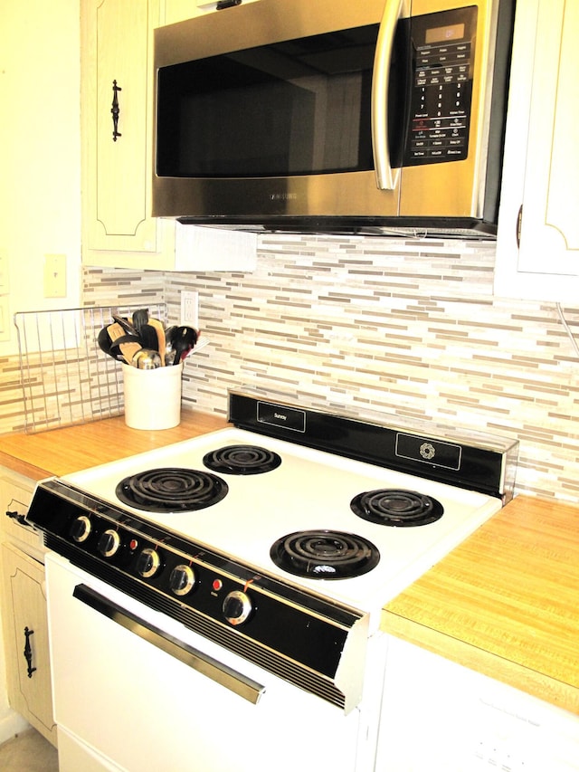 kitchen with white range with electric stovetop and tasteful backsplash