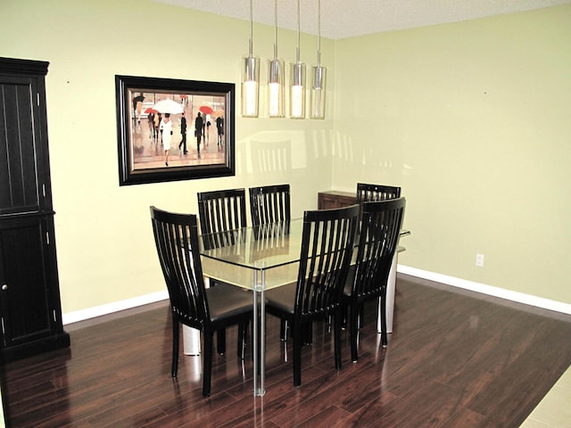 dining area featuring a textured ceiling and dark hardwood / wood-style flooring