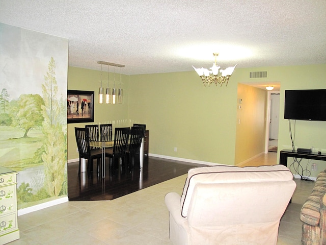 living room featuring tile patterned flooring, a chandelier, and a textured ceiling