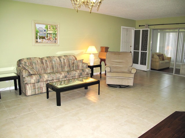 living room with a notable chandelier, light tile patterned floors, and a textured ceiling