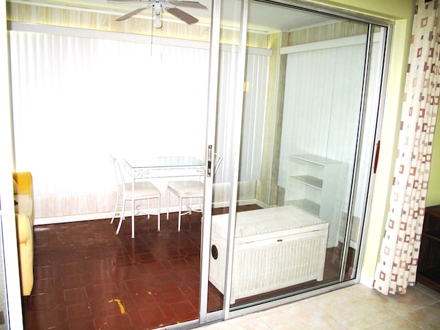 unfurnished sunroom featuring ceiling fan