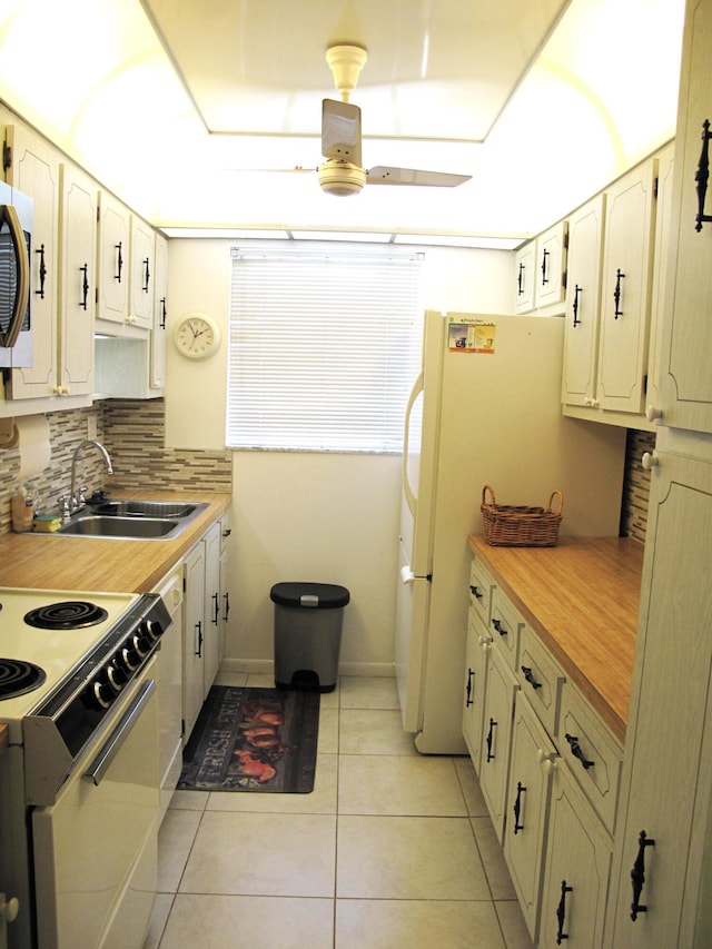 kitchen featuring white appliances, backsplash, sink, butcher block countertops, and light tile patterned flooring