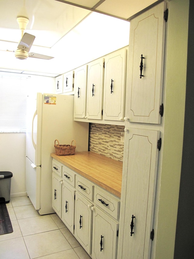 kitchen featuring light tile patterned floors, backsplash, and white refrigerator