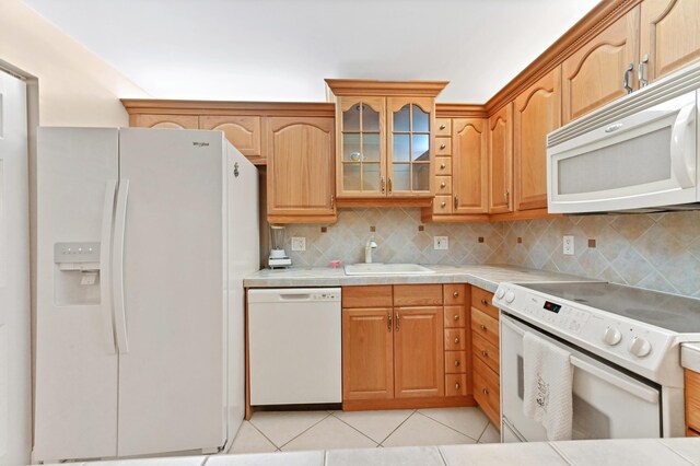 kitchen featuring tile countertops, white appliances, sink, light tile patterned floors, and tasteful backsplash